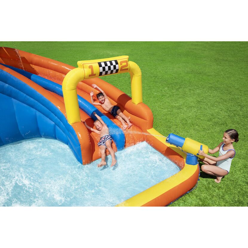 Zwei Kinder rutschen auf einer aufblasbaren Wasserrutsche.