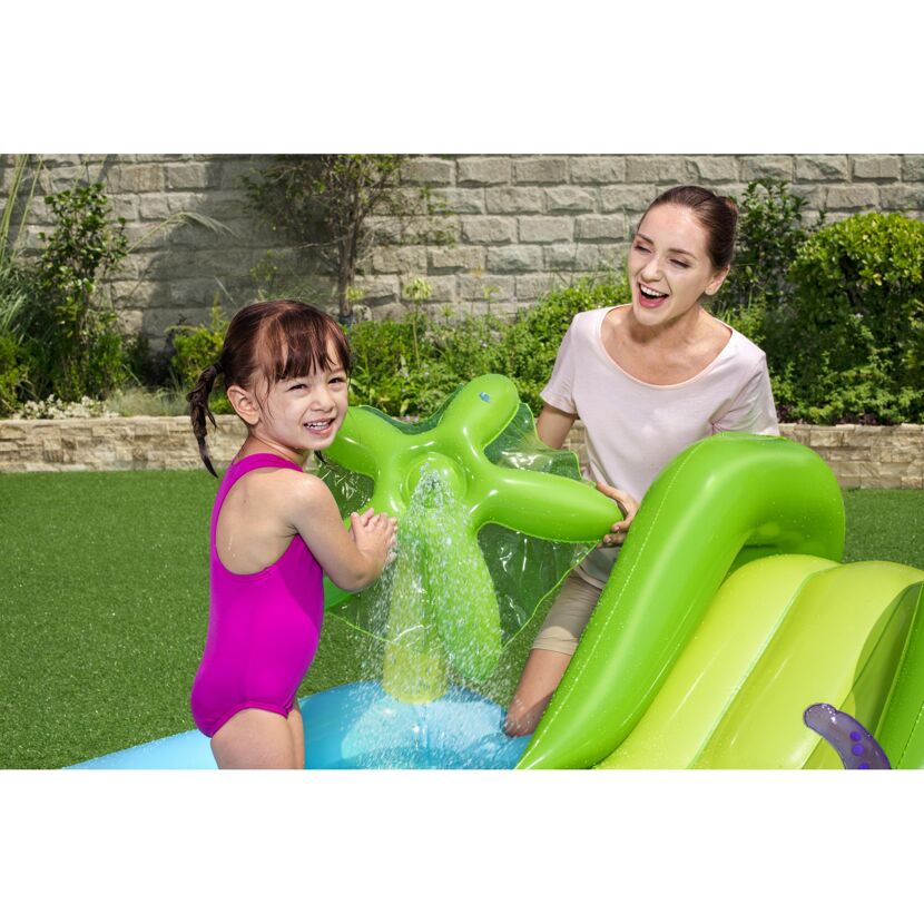 Kind und Erwachsene spielen in einem aufblasbaren Wasserspielcenter.