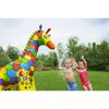 Zwei Kinder spielen im Garten mit einem aufblasbaren Wassersprinkler in Form einer Giraffe.