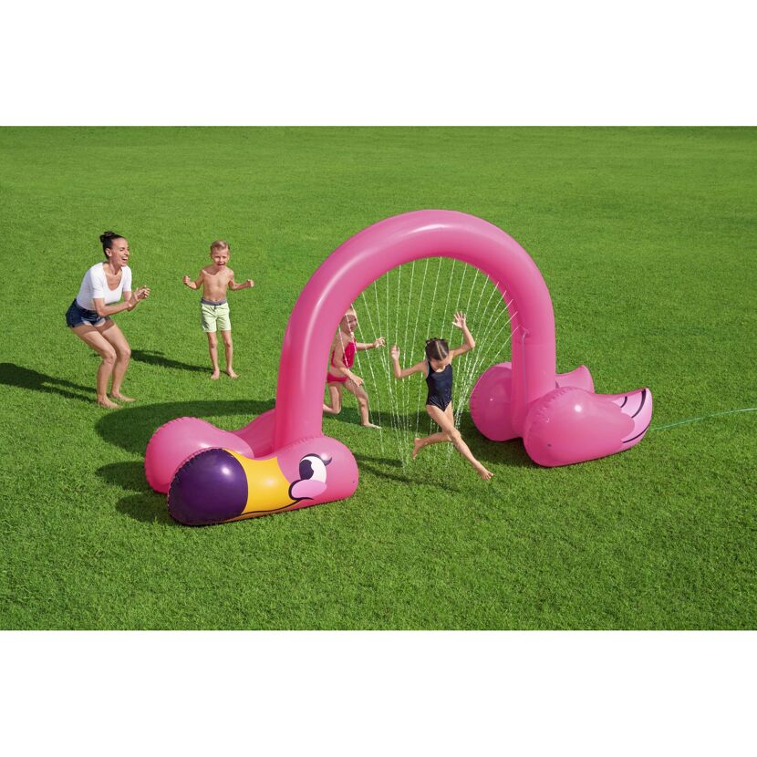 Kinder spielen mit einem aufblasbaren Wassersprinkler in Flamingo-Form.