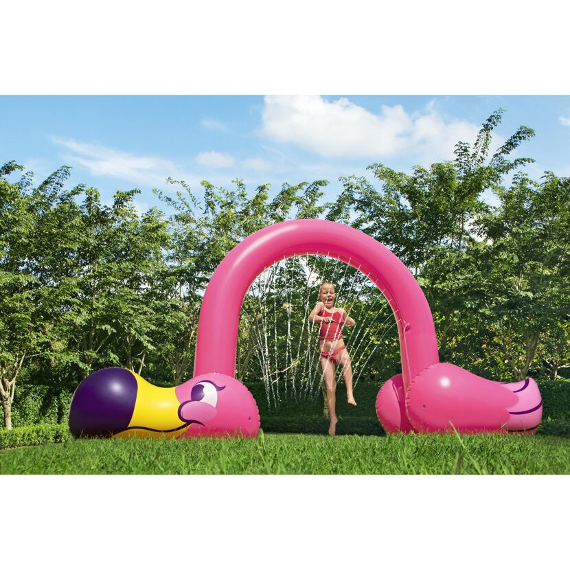 Kind spielt im aufblasbaren Wassersprinkler Flamingo