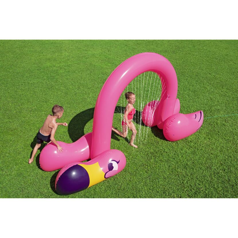 Zwei Kinder spielen mit einem aufblasbaren Flamingo Wassersprinkler.