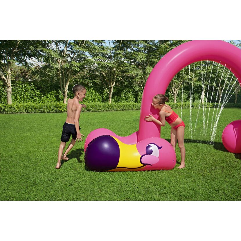 Zwei Kinder spielen mit einem aufblasbaren Wassersprinkler in Flamingo-Form.