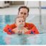 Baby mit Schwimmflügeln im Wasser