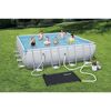 Mehrere Personen in einem rechteckigen Pool im Garten. Daneben liegt eine Solarheizmatte und eine Filterpumpe.