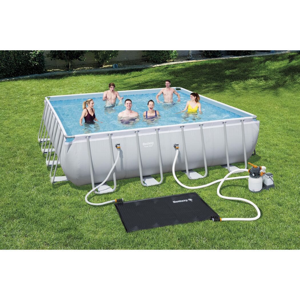 Mehrere Personen in einem rechteckigen Pool im Garten. Daneben liegt eine Solarheizmatte und eine Filterpumpe.