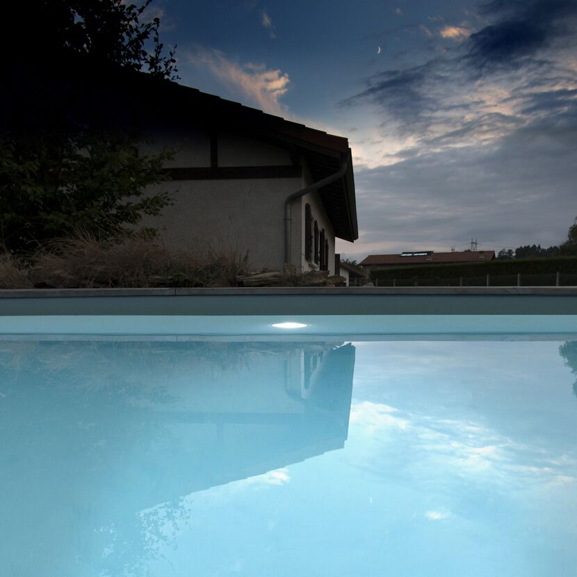 Beleuchteter Pool in der Abenddämmerung