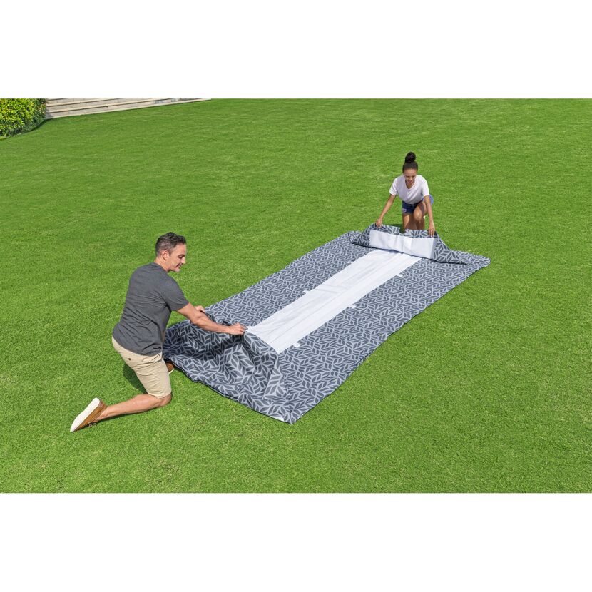 Zwei Personen breiten eine Picknickdecke aus