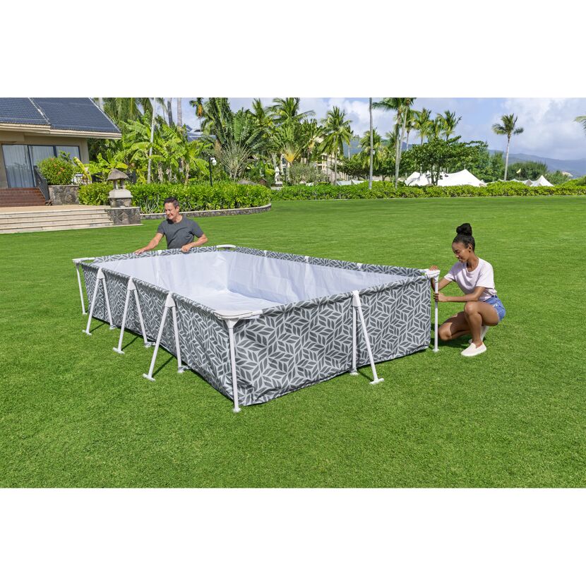 Zwei Personen bauen einen rechteckigen Pool auf.