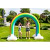 Zwei Kinder spielen unter einem aufblasbaren Regenbogen.