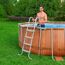 Person steigt Poolleiter aus aufblasbarem Pool