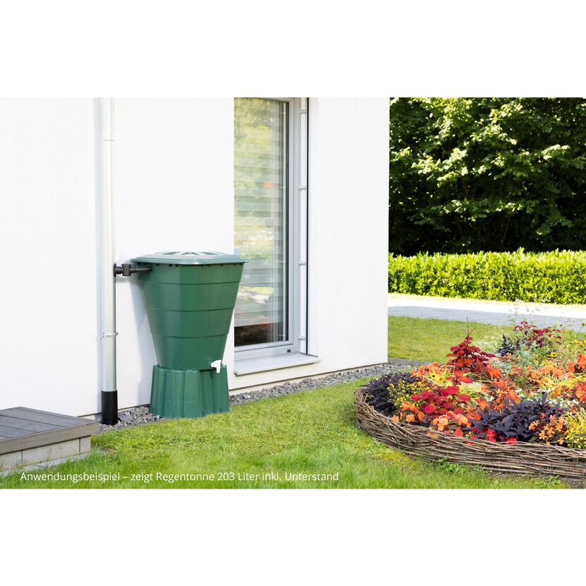 Grüne Regentonne an Hauswand mit Blumenbeet
