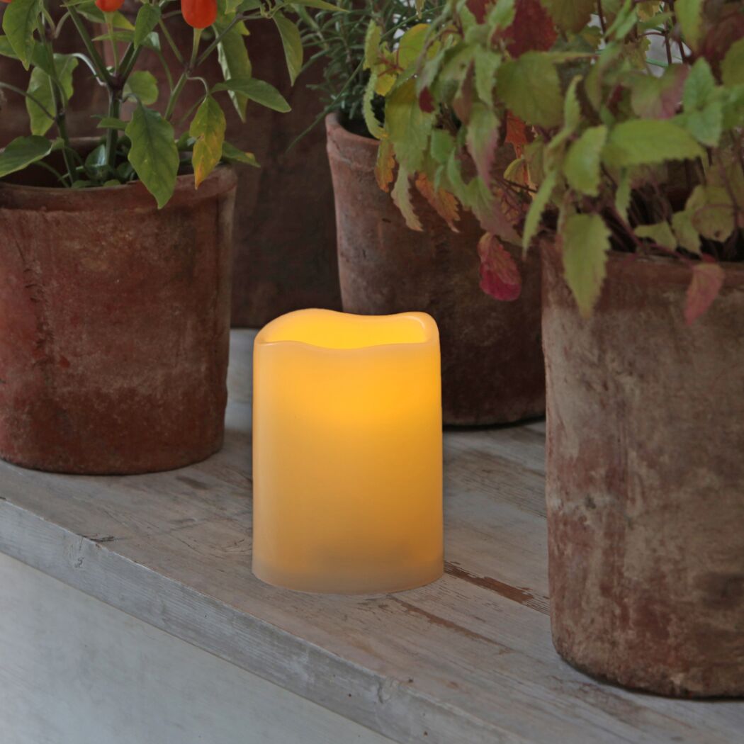 LED Kerze PICCOLO zwischen Blumentöpfen