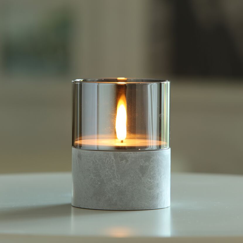 Brennende LED Kerze im Glas auf Sockel