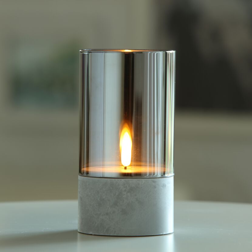 LED-Kerze in einem Glasbehälter auf einem Tisch
