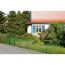 Grüner Maschendrahtzaun vor einem Haus