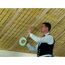 Person verklebt Dachsparren mit Montageband.