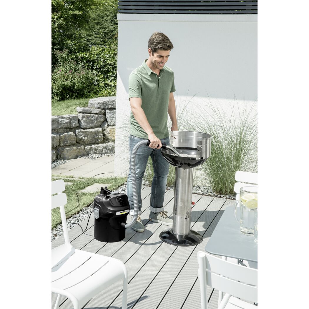 Person saugt Asche mit Kärcher Aschesauger aus Grill