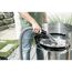 Person saugt Asche mit einem Aschesauger aus einem Grill.