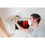 Person schleift mit Handschleifer eine Decke