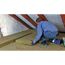 Person verlegt Mineralwolle-Dämmplatten auf dem Dachboden.