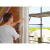 Person bringt Fensterband an Fensterlaibung an.