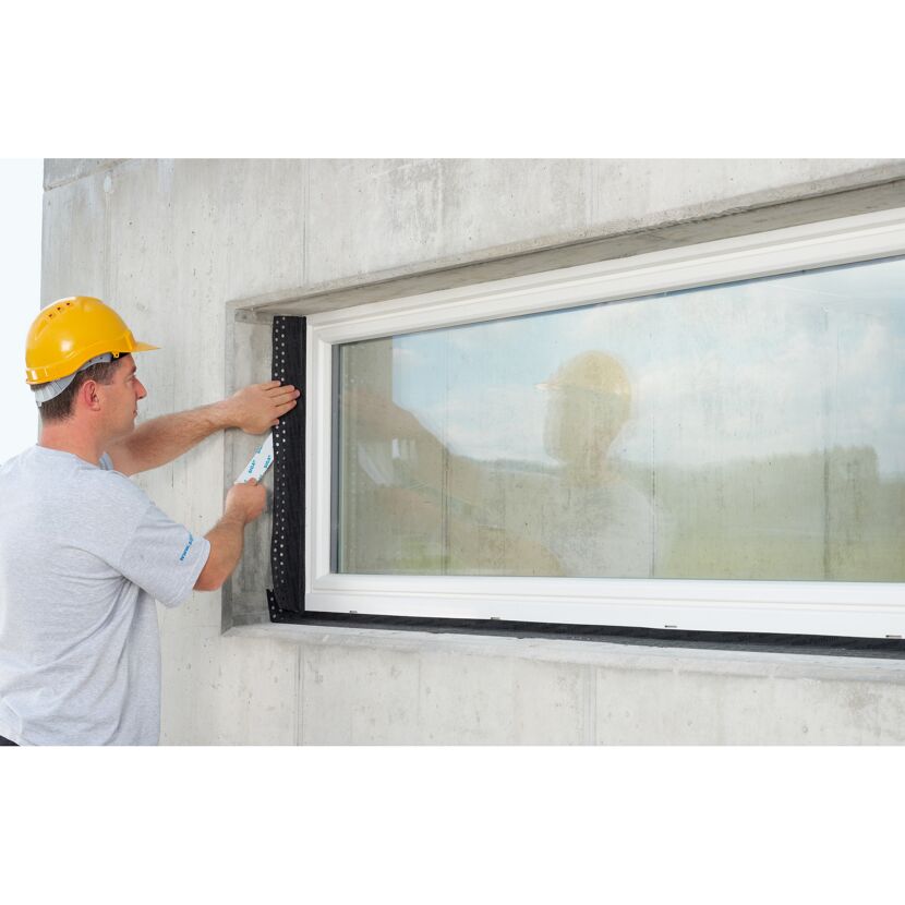 Person bringt Fensterband an Fenster an.