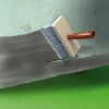 Graue Dichtungsmasse wird mit Pinsel aufgetragen
