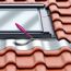 Pinsel beim Auftragen von Dichtmittel auf Dachfenster