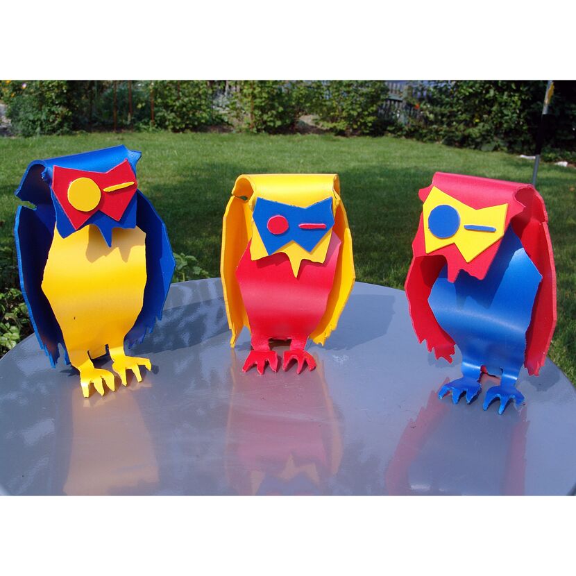 Drei bunte Eulen aus Kunststoff.