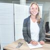 Person schreibt mit Kugelschreiber hinter Thekenaufsatz