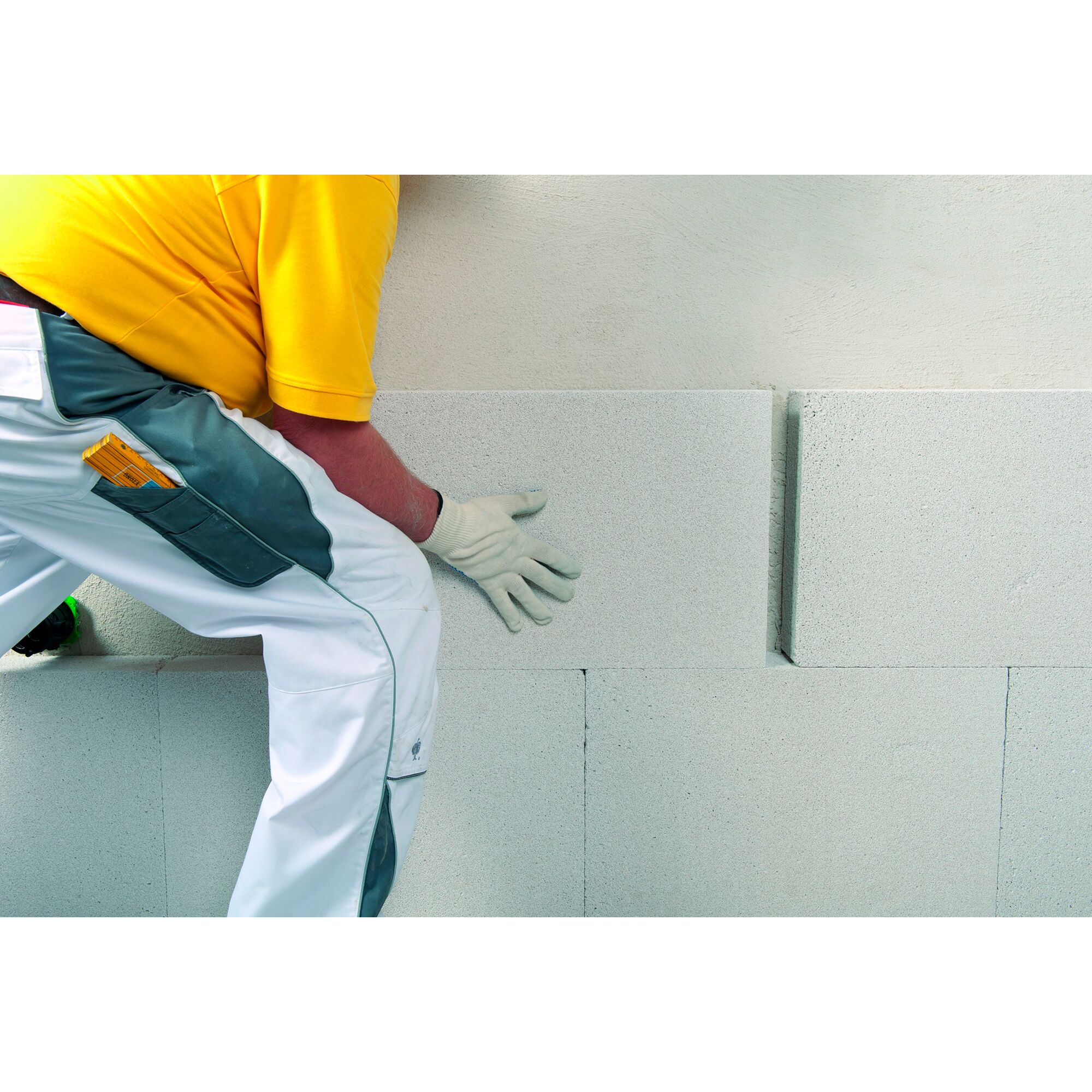 Person baut eine Wand aus Ytong Multipor.
