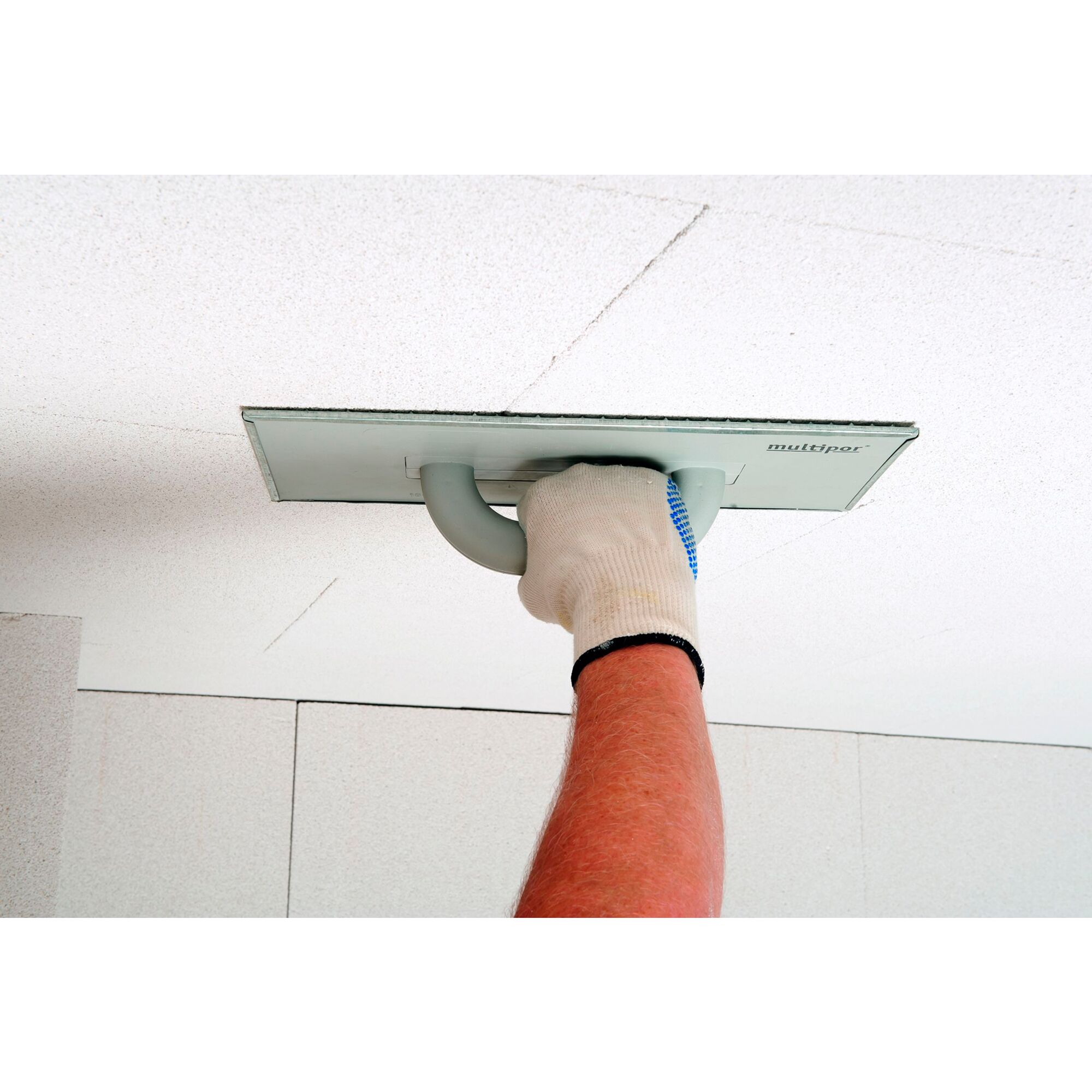Person verwendet Schleifbrett von Multipor an Decke
