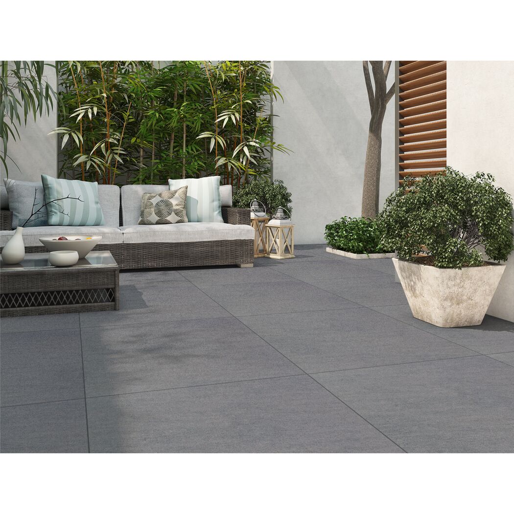 Gepflasterte Terrasse mit Gartenmöbeln und Pflanzen.