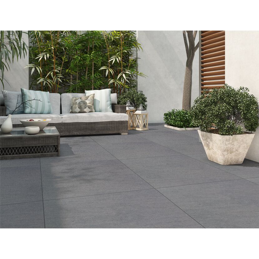 Gepflasterte Terrasse mit Gartenmöbeln und Pflanzen.