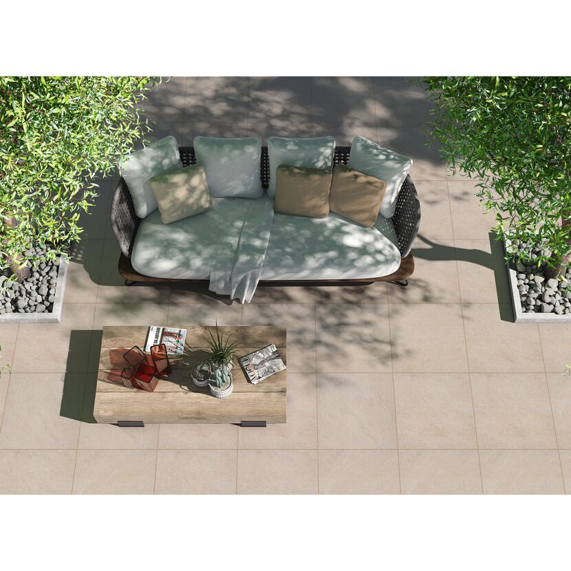 Gepflasterte Terrasse mit Sofa, Tisch und Bäumen
