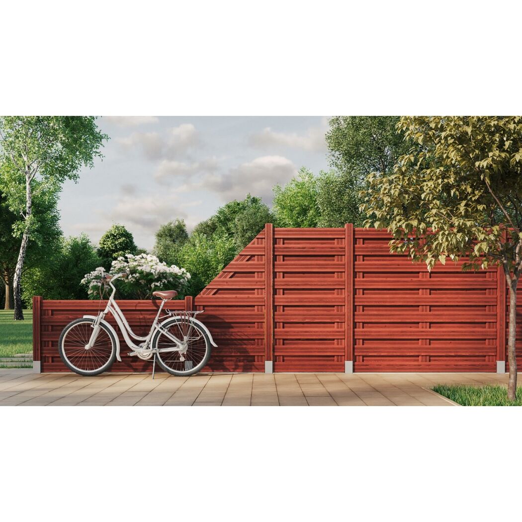 Fahrrad an einem roten Sichtschutzzaun gelehnt.