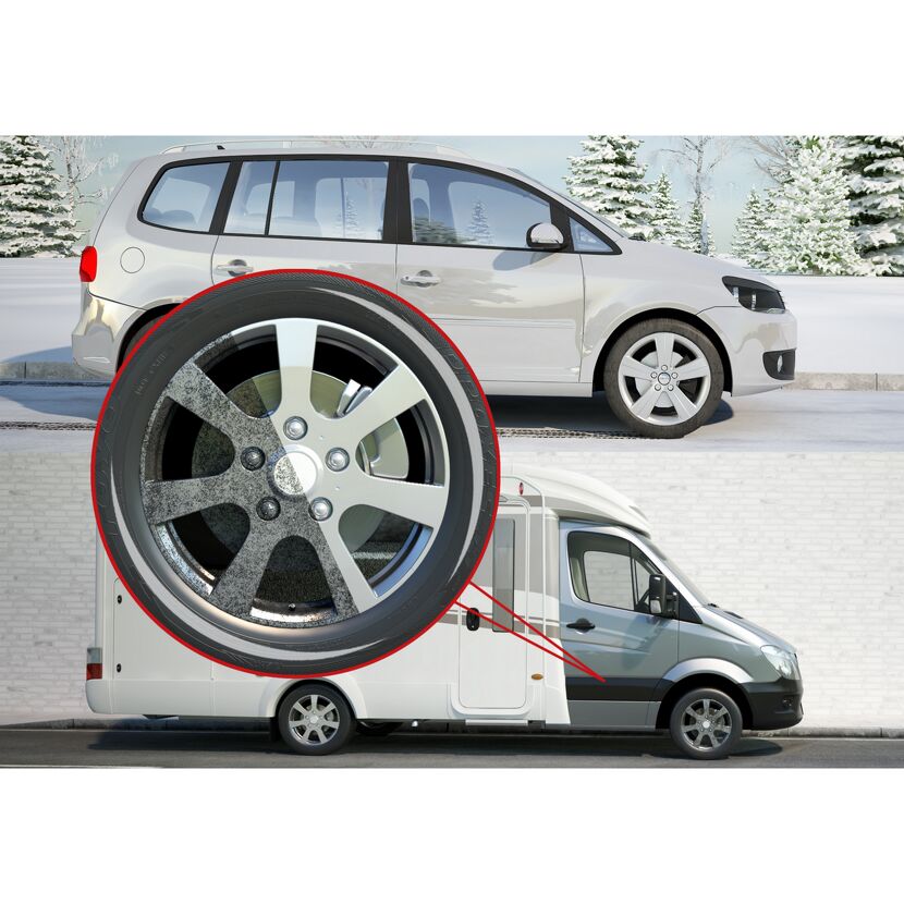 Autoreifen und Felge, daneben ein Wohnmobil