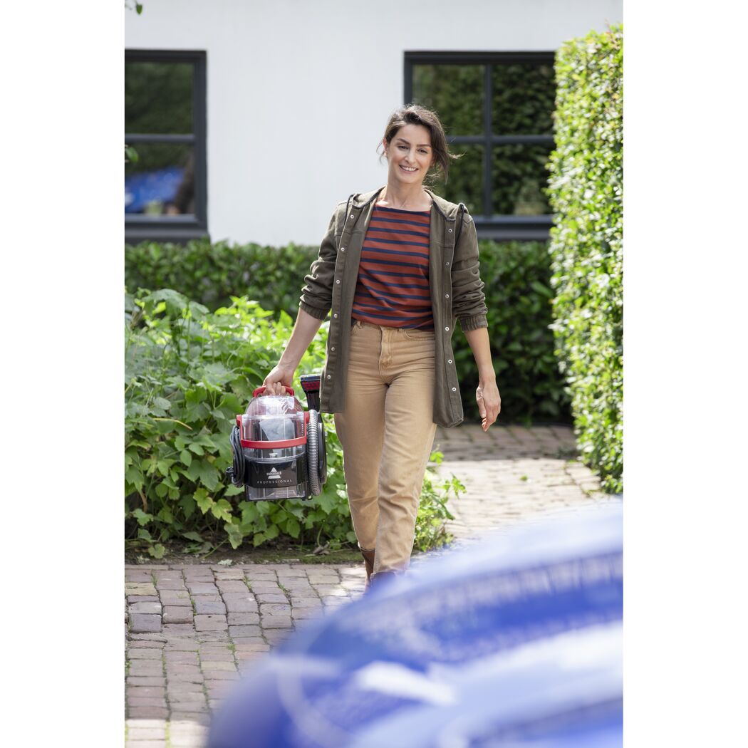 Person trägt einen tragbaren Teppichreiniger