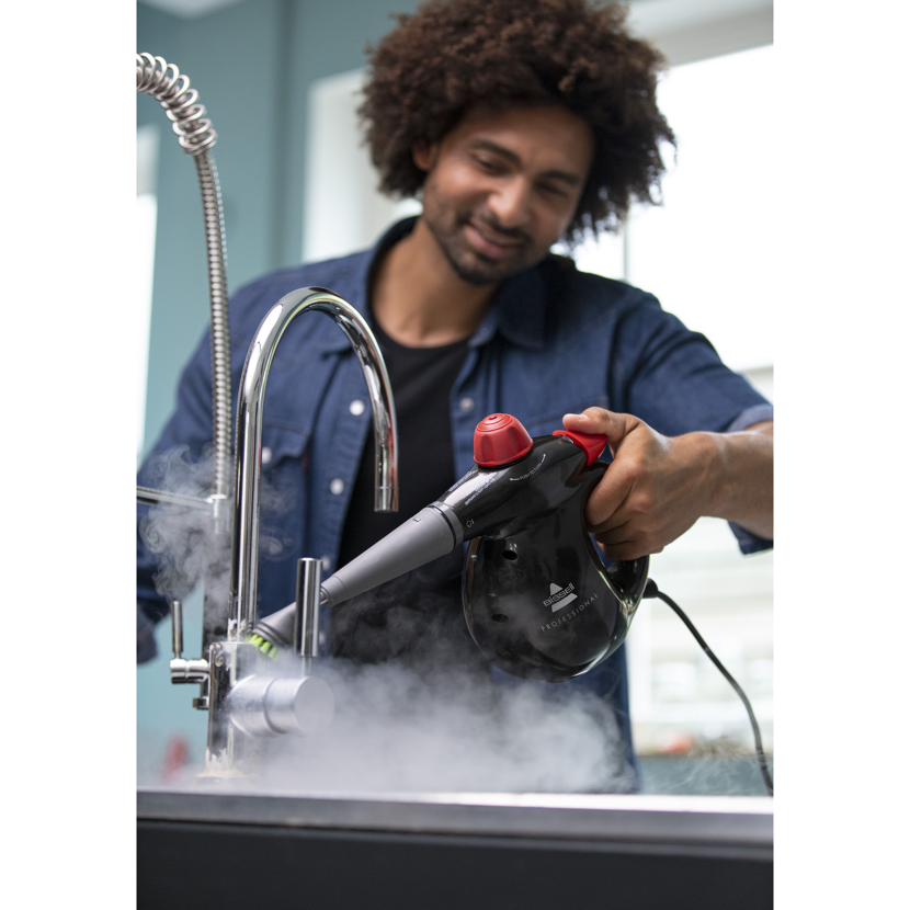 Person reinigt Wasserhahn mit BISSELL SteamShot