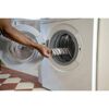 Person legt Steinwalze in Waschmaschine