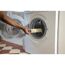 Person wäscht eine Farbrolle in der Waschmaschine.