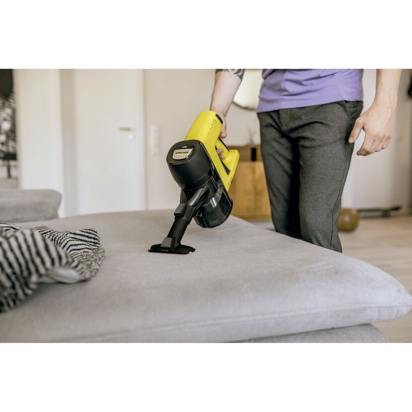 Person saugt Sofa mit dem Kärcher Akku-Handstaubsauger VC 4 Cordless myHome