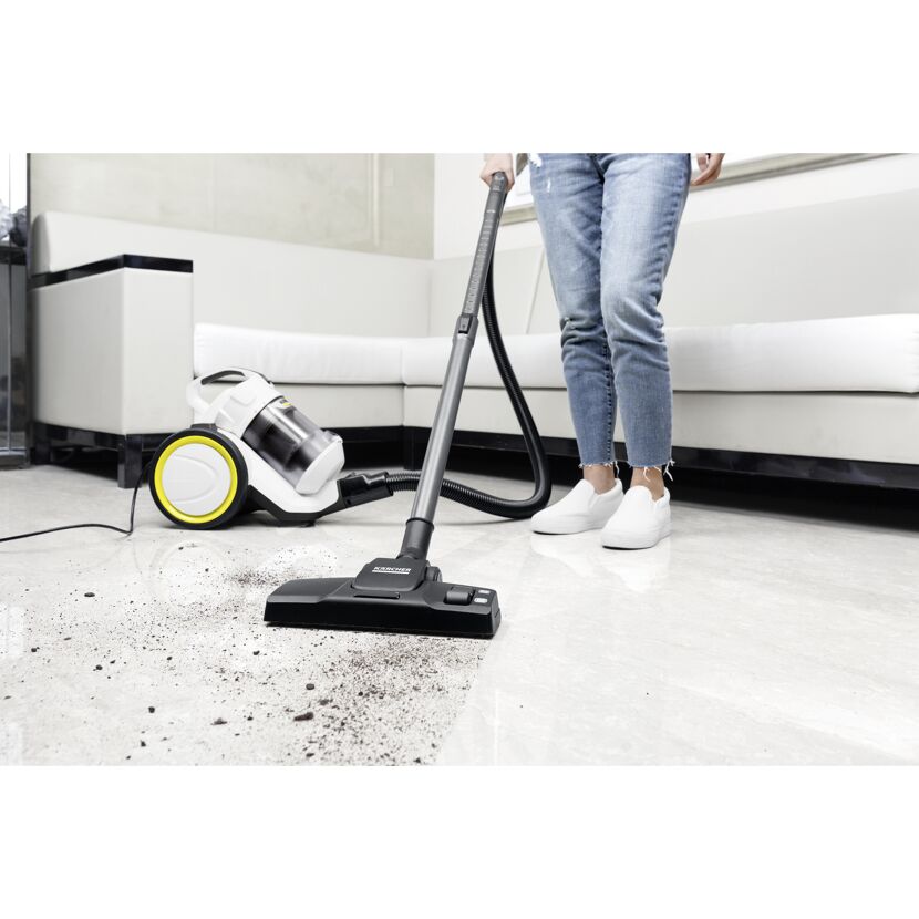 Person saugt mit Staubsauger Krümel