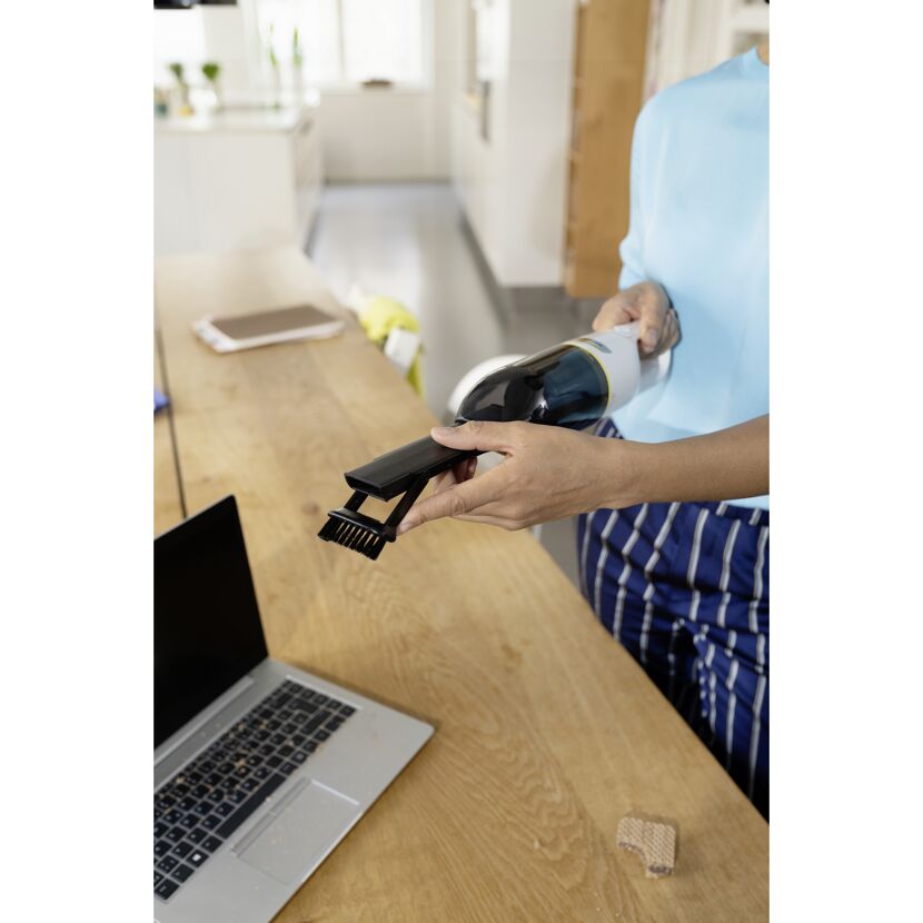 Person hält Handstaubsauger