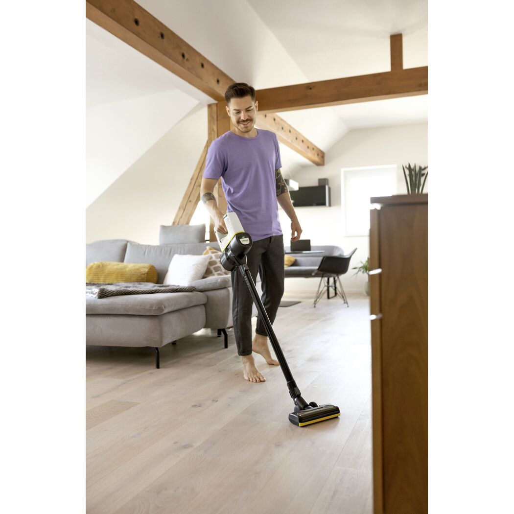 Person saugt mit Akkustaubsauger