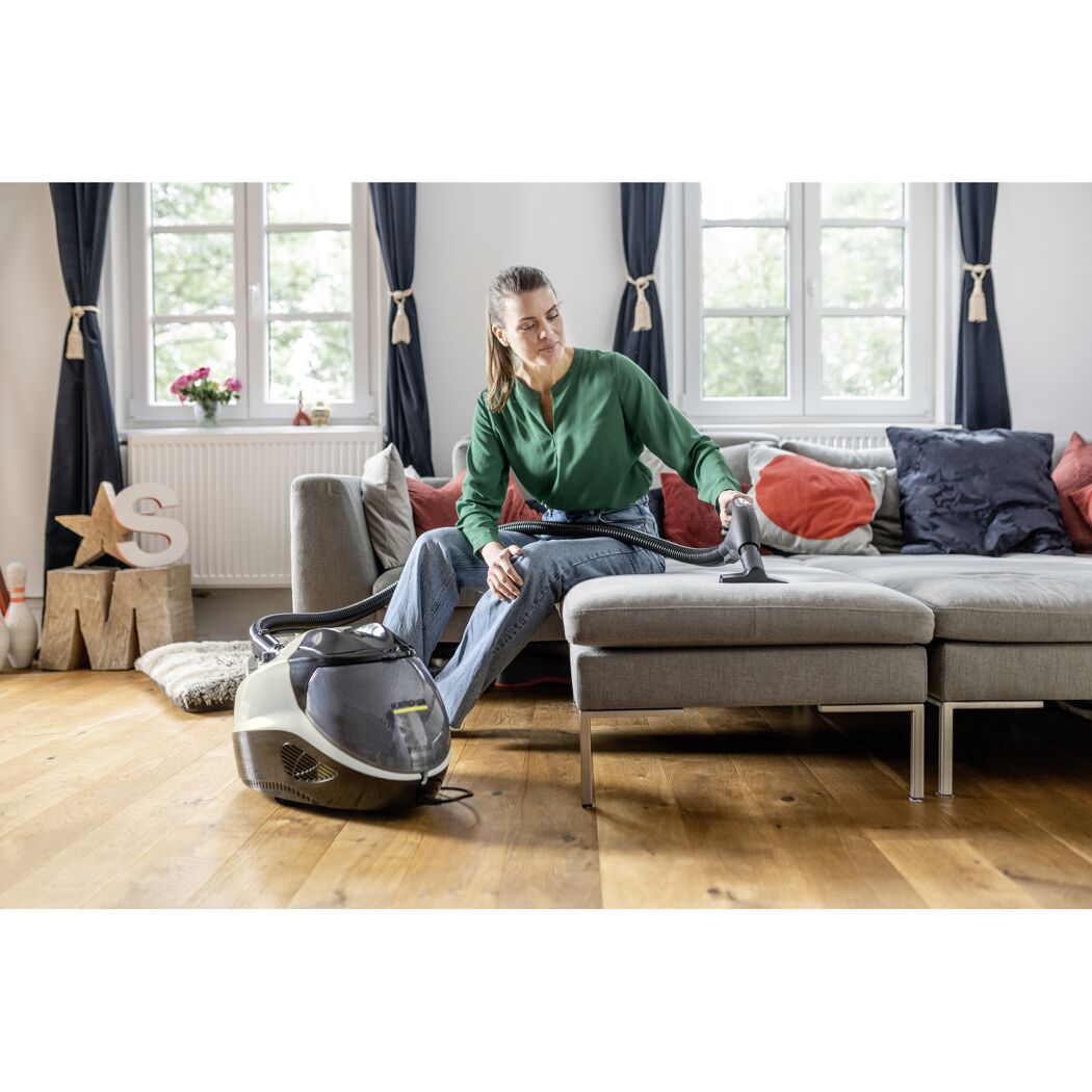 Person reinigt Sofa mit Dampfreiniger