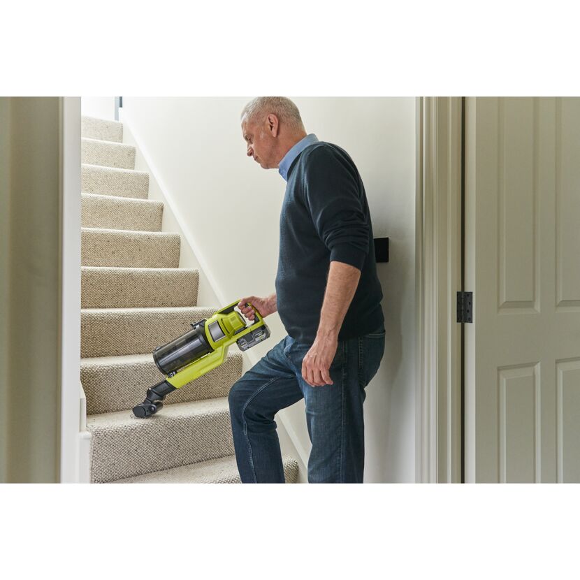Person saugt mit Akkusauger Treppe