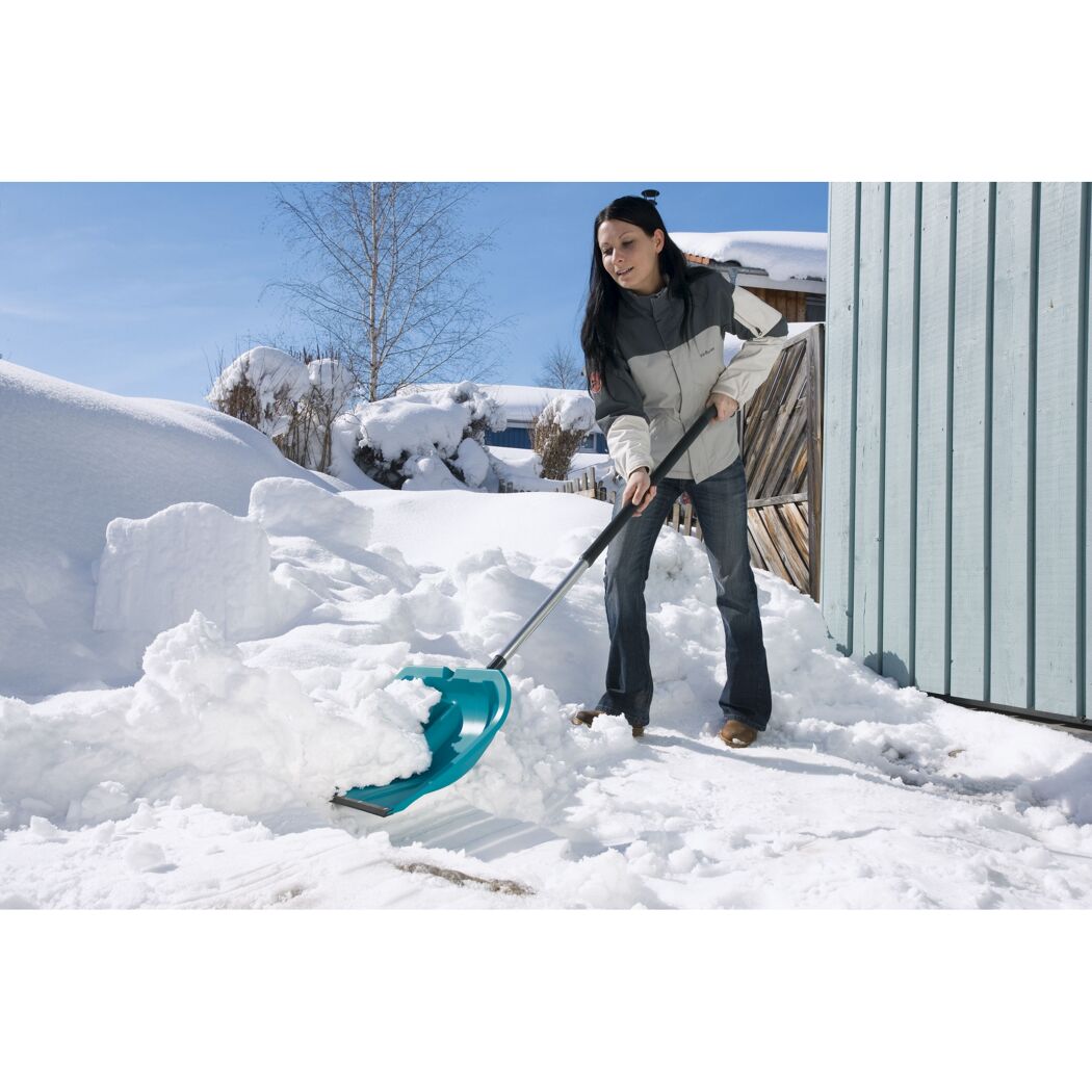 Person räumt Schnee mit Schneeschieber