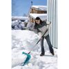 Person räumt Schnee mit Schneeschieber